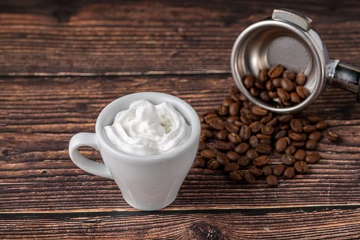 Espresso con panna in white porcelain cup on wooden table