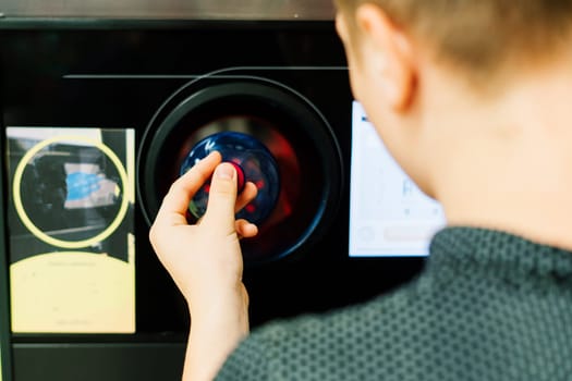 Reverse vending recycling machine that dispenses cash. Man hand puts plastic bottle to machine