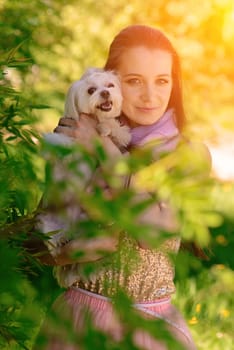 Young woman with her dog. Puppy white dog is running with it's owner. Concept about friendship and animal.