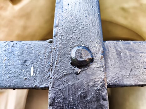 Rivet on a metal cross. An old wrought-iron fence. Abstract Background, texture, frame, copy space, place for text