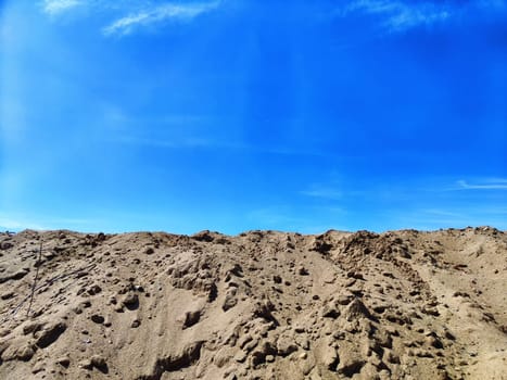 View of high sand dune with footprints and blue sky. Natural location and place for photography