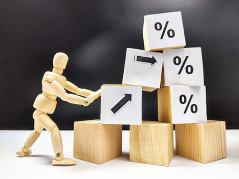 Little wooden man, cubes in a pyramid and growth arrows and percent signs. The concept of applying efforts that lead to results. Scammers offering huge profits without difficulty