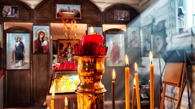 Kirov, Russia - April 16, 2023: Candles in a Christian Orthodox church background. Flame of candles in the dark sacred interior of the temple