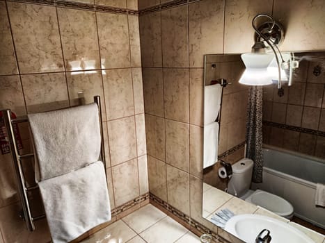 Perm, Russia - July 04, 2023: Modern bathroom interior with stylish mirror, towel, vessel sink