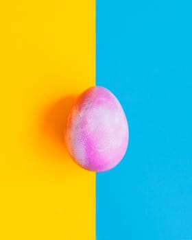 Cosmic galactic Easter egg on blue and yellow pastel background