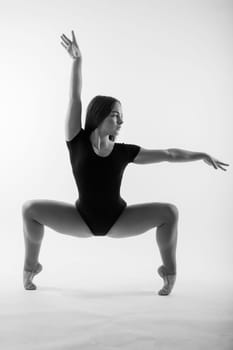 Beautiful plump brown-haired woman in black bodysuit in studio. Caucasian dancehall dancer posing