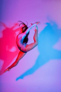 Beautiful plump brown-haired woman in black bodysuit in studio. Caucasian dancehall dancer posing