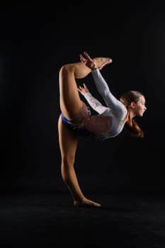 Beautiful plump brown-haired woman in black bodysuit in studio. Caucasian dancehall dancer posing