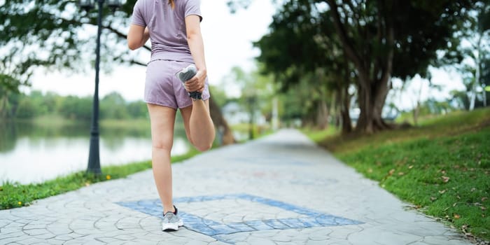 Young woman stretch during stretching exercise outdoors in the park.