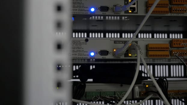 back of the server installed in the server room. Many cables are connected to a powerful computers. Front panel of the central router. Optical links of a powerful Internet server. Connection of optical wires in the data center server room.