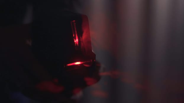 Man's hand holding the barcode scanner and shining in the dark. Close-up