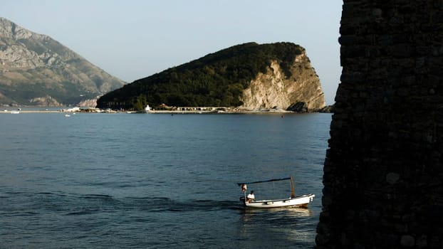 Beautiful landscape with sea view. Creative . The sea is located next to the green mountains, boats are sailing, tourists are walking and the blue sky is visible. High quality FullHD footage