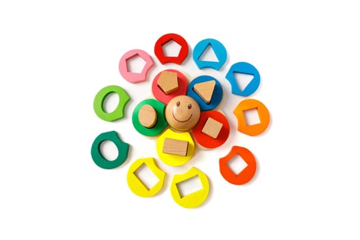 Wooden children's puzzle toy with colorful blocks of different shapes in form of funny sun, isolated on white background.