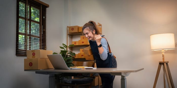 Asian women are achievement success with sale growth. Happy women selling product online with laptop. Successful and happy concept.