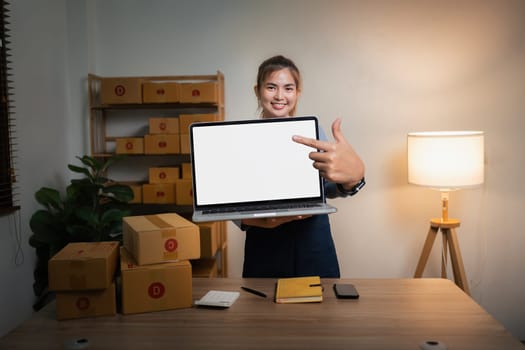 Joyful asian woman, showing her laptop with empty white mockup screen, rejoices in success, looks at camera, make YES gesture.