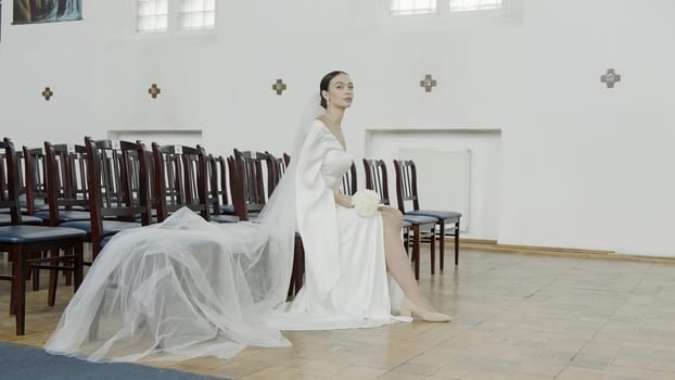 A beautiful bride. Action.Photographing in the registry office where they shoot a pretty girl with big eyes in a wedding white dress with a veil. High quality 4k footage