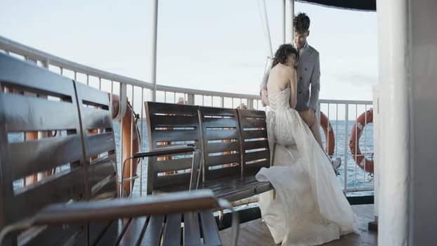 Newlyweds are sailing on boat. Action. Beautiful couple of newlyweds are sitting on boat. Stylish couple of newlyweds sail on tourist steamer.