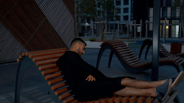 A resting adult male. Media. After a hard evening, spending time on a bench in peace. High quality 4k footage