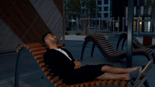 A resting adult male. Media. After a hard evening, spending time on a bench in peace. High quality 4k footage