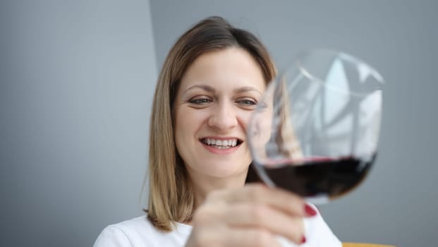 Portrait of young woman with glass of red wine in her hand. Alcohol dependence in women concept