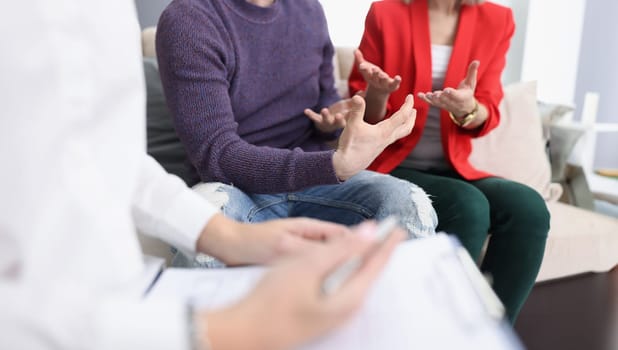 Young couple communicating with psychologist in office closeup. Family psychologist concept