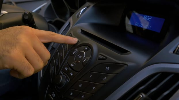 Man's hand puts the disk into the car player. Button control for compact disk player in a car. Hand puts the disk into the radio car HD