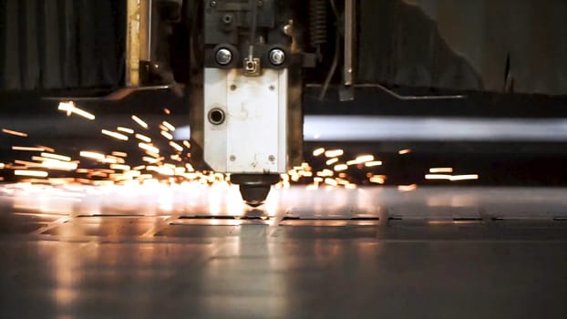 Cutting of metal. Sparks fly from laser. Clip. Laser cutting machine technology. Industrial Laser cutting processing manufacture technology of flat sheet metal steel material with sparks. Laser close-up.