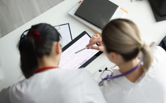 Doctors studying electrocardiogram on digital tablet closeup. Medical education concept