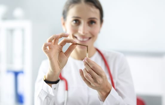 Woman doctor holding broken cigarette in clinic closeup. Smoking control concept