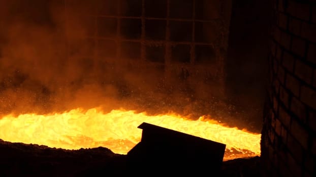 Liquid metal from blast furnace. Liquid metal pouring stream.