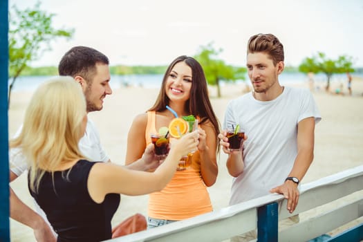 Friends having fun at the bar outdoors, drinking cocktails. Summer bar