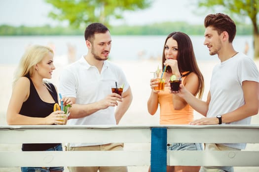 Friends having fun at the bar outdoors, drinking cocktails. Summer bar