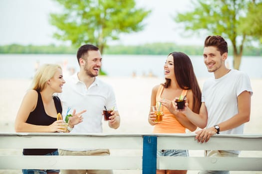 Friends having fun at the bar outdoors, drinking cocktails. Summer bar