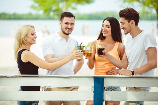 Friends having fun at the bar outdoors, drinking cocktails. Summer bar