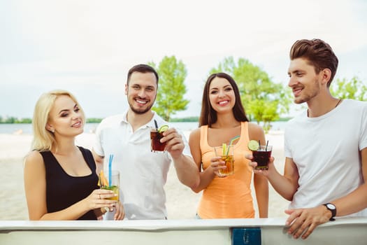 Friends having fun at the bar outdoors, drinking cocktails. Summer bar