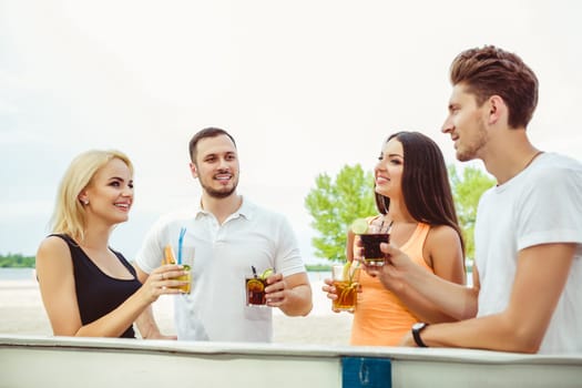 Friends having fun at the bar outdoors, drinking cocktails. Summer bar