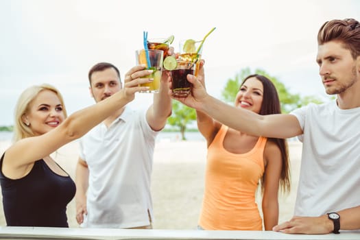 Friends having fun at the bar outdoors, drinking cocktails. Summer bar