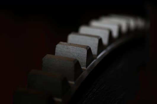 Closeup of metal cogwheel on dark background as part of full machine and steampunk concept