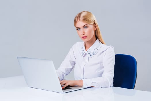 Young businesswoman working at laptop computer. she sits smiling