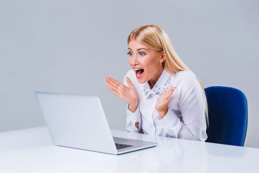 Young businesswoman working at laptop computer. surprised pleased