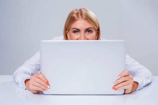 Young businesswoman working at laptop computer. hiding behind the monitor