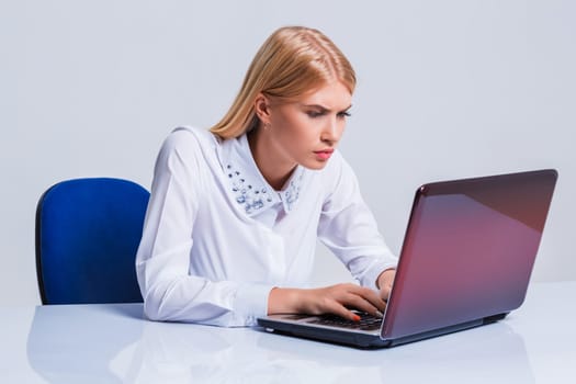 Young businesswoman working at laptop computer. pleasantly surprised dissatisfied girl