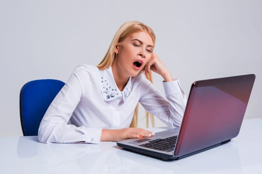 Young businesswoman working at laptop computer. tired girl soon fell asleep stress. yawns