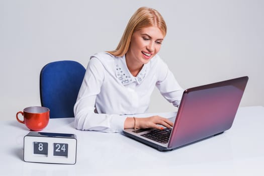 Young businesswoman working at laptop computer. Pretty smiling girl