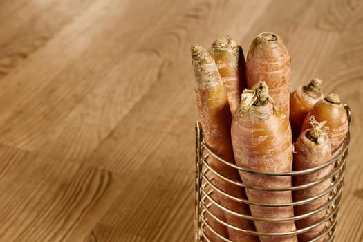 Bunch of orange carrots in bowl on wooden table ,