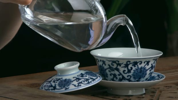 Process brewing tea,tea ceremony,Cup of freshly brewed black tea. Asian tea set on bamboo mat,Closeup. The chinese from a cast teapot 4K