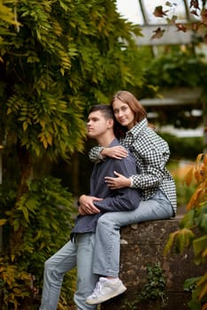 Young Cute Female Hugs Boyfriend. In Autumn Outdoor. Lovers Walking in Park. Attractive Funny Couple. Lovestory in Forest. Man and Woman. Cute Lovers in the Park. Family Concept. Happy Couple.