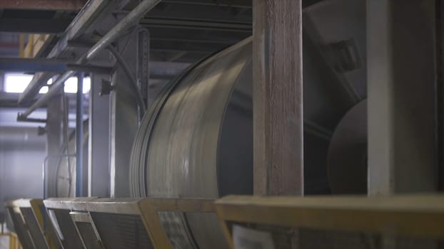 Ore dressing mill or factory grinder at the plant workshop. Rotating machines at the construction materials factory, industrial background.