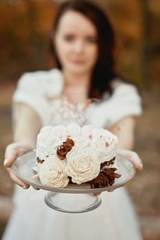 bride on the nature in autumn . the bride with cake at the wedding.