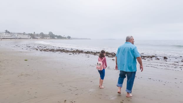 Walking along the shore of Miramar Beach, California, the overcast winter sky creates a tranquil and reflective atmosphere.